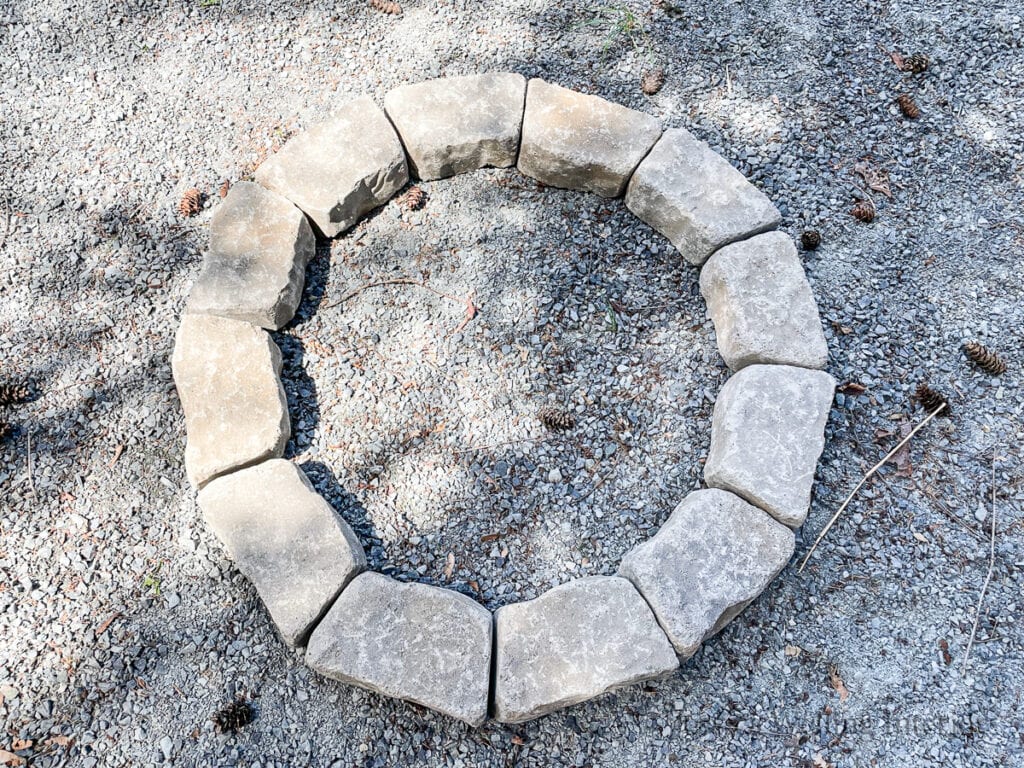 overhead view of the first layer of concrete bricks laid out in a circle to make a DIY fire pit