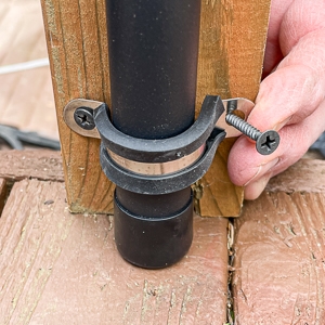 close-up of string light pole being installed on a deck railing