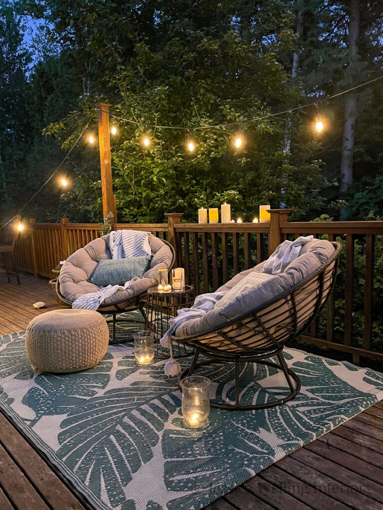 low light photo of a cozy Boho outdoor living room with glowing string lights and candles