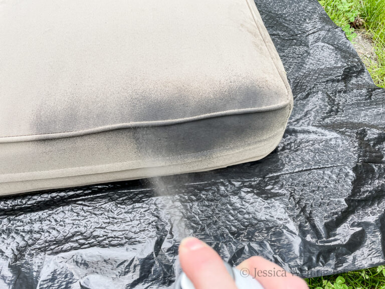beige outdoor cushion being spray painted grey with outdoor fabric paint