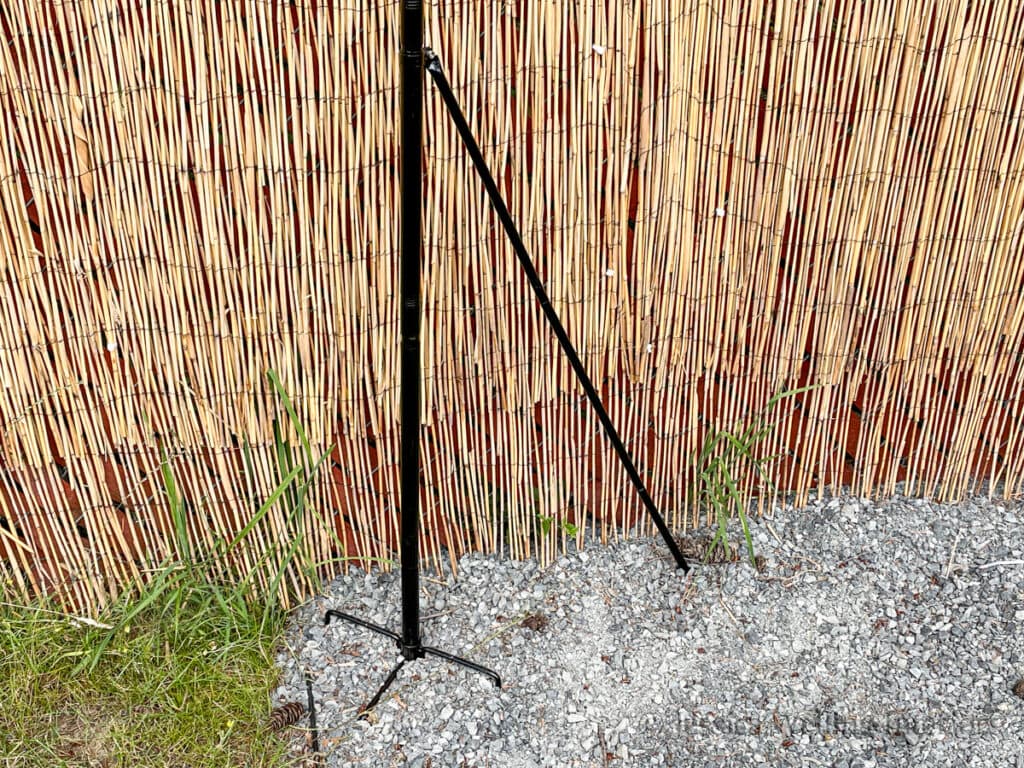 fork-style string light pole with support piece installed on a gravel patio