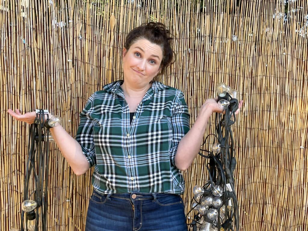 woman holding several strands of string lights