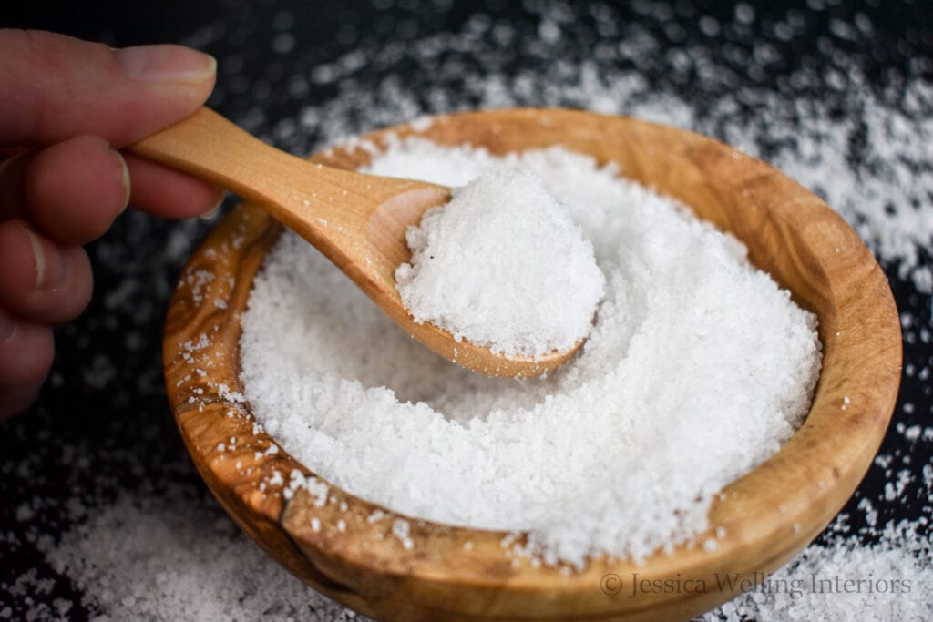bowl of homemade Dead Sea bath salts with a wood scoop