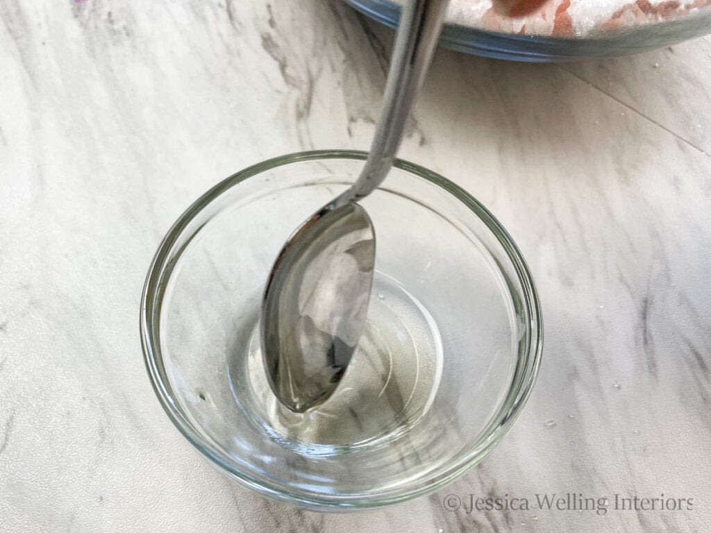 spoon stirring essential oils into carrier oil