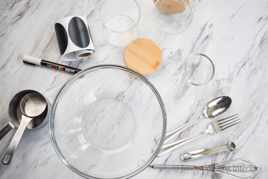 tools and material to make DIY bath salts on a countertop- mixing bowl, measuring cups and spoons, glass jars, etc.