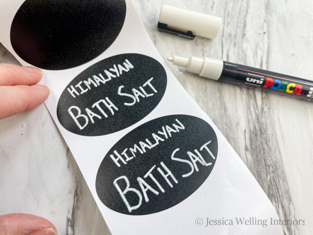 roll of chalkboard sticker labels with "Himalayan Bath Salt" written on them with a white paint pen