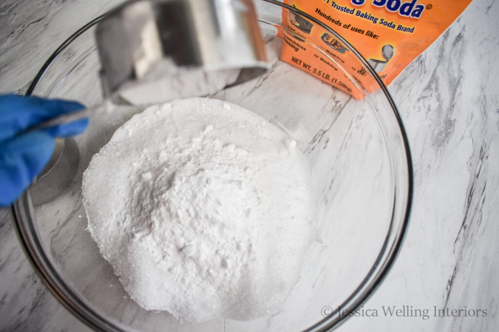 overhead view of a glass mixing bowl with epsom salt and baking soda