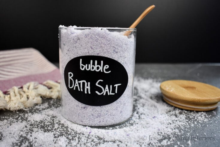 glass jar of bubbling bath salt with a wood scoop