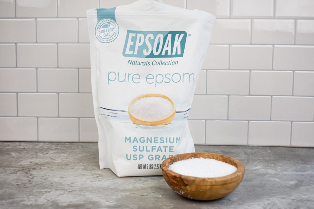 bag and wood bowl of unscented epsom salt on a countertop