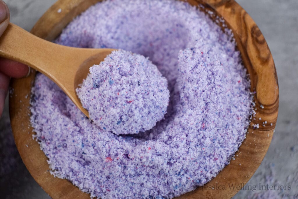 wood bowl of DIY fizzy bath salts with a wood scoop
