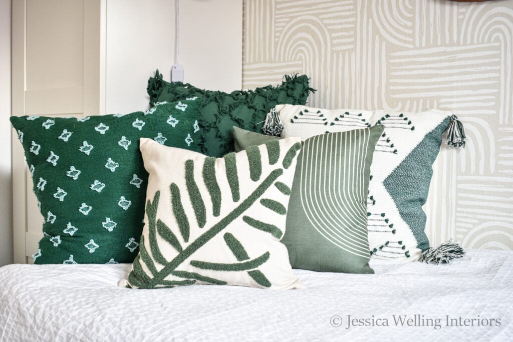 5 modern Boho green pillow covers on a bed
