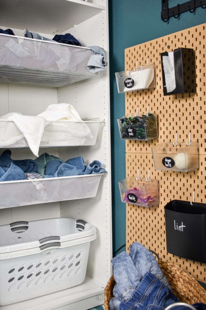 laundry room cabinet and pegboard with bins for detergent pods, a lint bin, etc.