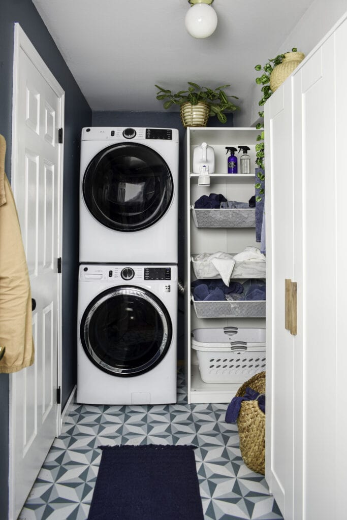 small laundry room with  stacked washer and dryer and cabinets