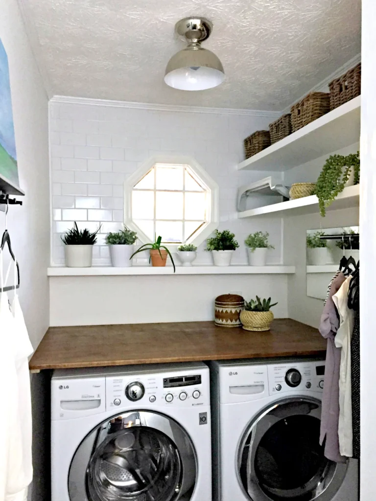 small laundry room with a DIY wood countertop over the washer and dryer and clothes drying rods